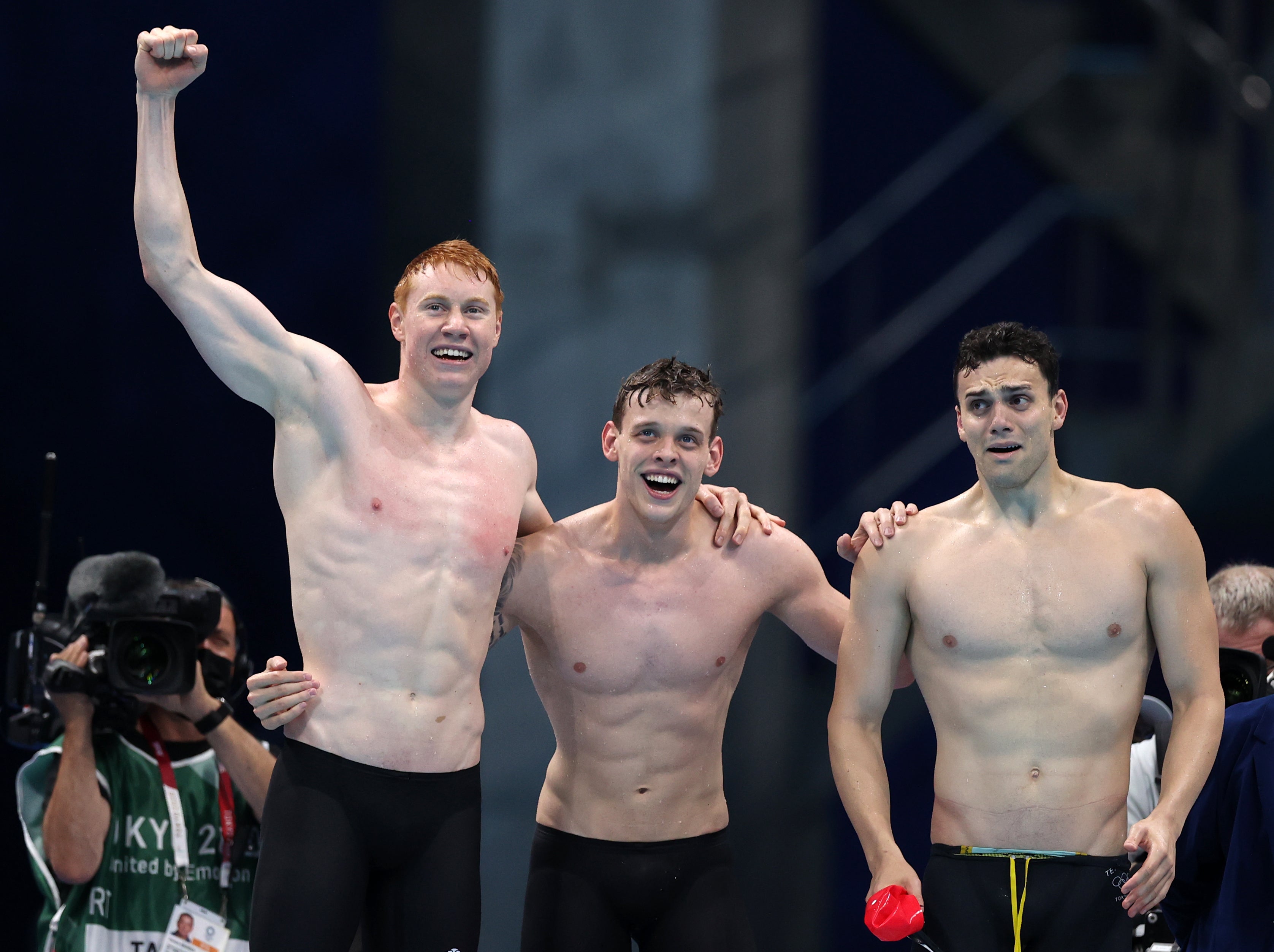 Tom Dean, James Guy and Matthew Richards of Team Great Britain react as teammate Duncan Scott (not pictured) swims the anchor leg during the Men's 4 x 200m Freestyle Relay Final