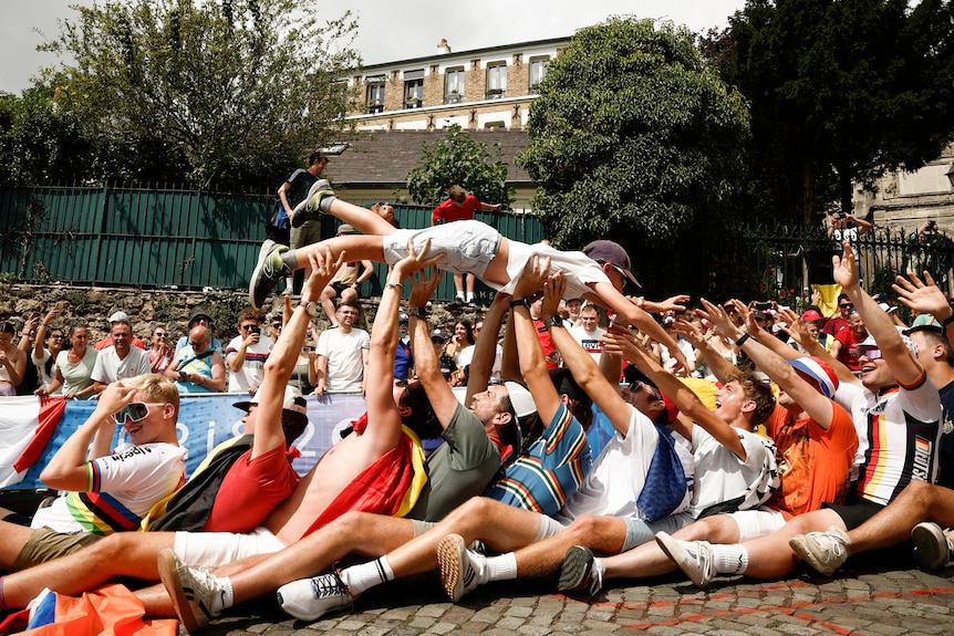 Spectators crowd surf a child