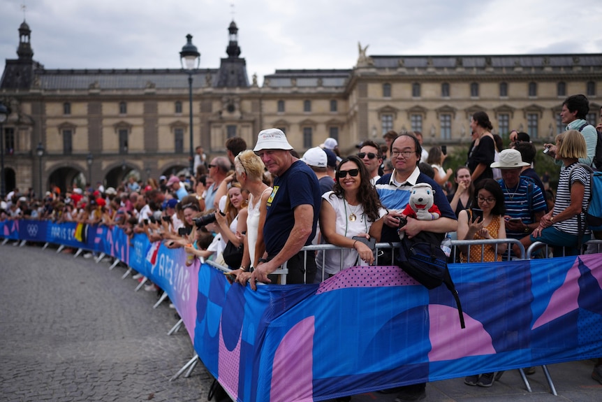 Fans stand next to barriers