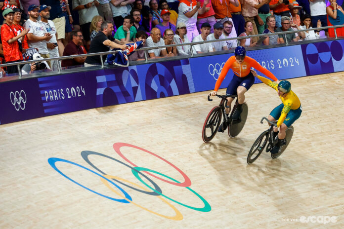 Harrie Lavreysen and Matthew Richardson pat one another on the back after their sprint final at the 2024 Paris Olympics, the Olympic rings emblazoned on the steep boards of the track just in front of them.