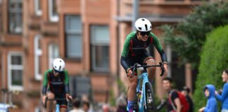 Two women in green cycling kit on bicycles