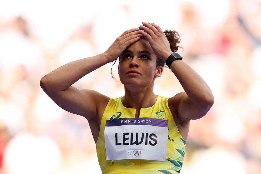 Torrie Lewis touches her head after her 200m heat