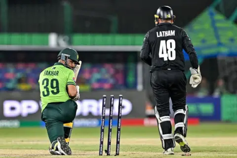 AFP Pakistan's Fakhar Zaman (L) looks at the stumps after being clean bowled during the ICC Champions Trophy cricket match between Pakistan and New Zealand at the National Stadium in Karachi on February 19, 2025.