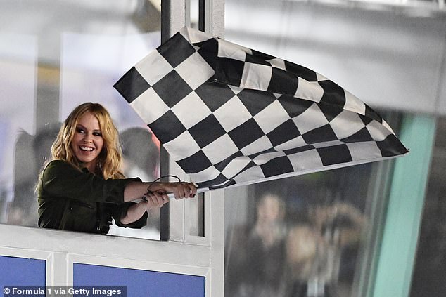 F1 Fan: Kylie Minogue waves the chequered flag at the Singapore Grand Prix in 2024