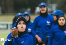 Afghan player Tooba Sarwari looks up with her hands held out during her team's match against Cricket Without Borders