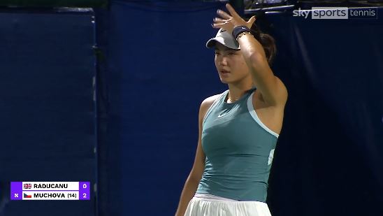 Emma Raducanu wiping her brow during a tennis match.