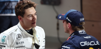 George Russell and Max Verstappen talk to each other in the pit lane