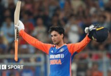 Abhishek Sharma celebrates his hundred against India by raising his bat and helmet