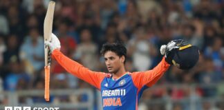 Abhishek Sharma celebrates his hundred against India by raising his bat and helmet