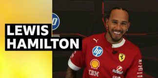 Lewis Hamilton smiles in Ferrari training top