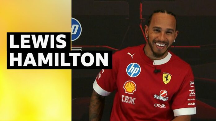 Lewis Hamilton smiles in Ferrari training top