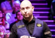 Matthew Selt chalking his cue during a match