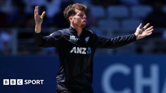 New Zealand's Mitchell Santner holds his arms out wide after bowling