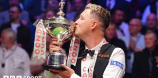 Kyren Wilson kisses the World Championship trophy