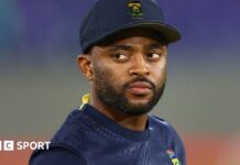 Temba Bavuma, wearing a dark blue South Africa cap and training shirt, looks to his right