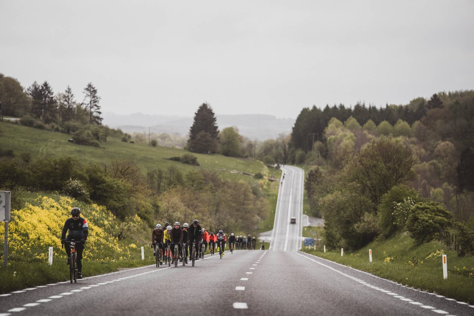 Riders cycling across the harsh Ardennes landscape at Liege-Bastogne-Liege Sportive