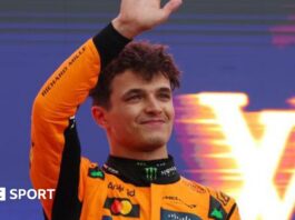 Lando Norris waves on the podium as he celebrates winning the Australian Grand Prix