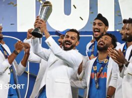 India players wearing their tailored white jackets as they lift the Champions Trophy