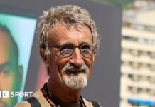 Eddie Jordan smiles while posing for a photograph