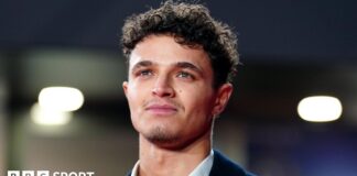 Lando Norris wearing a jacket and open-neck shirt