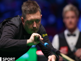 Kyren Wilson plays a shot with the extended rest