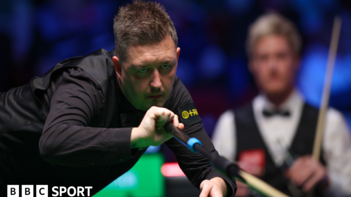 Kyren Wilson plays a shot with the extended rest