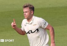 Sam Curran with his finger in the air after taking a wicket for Surrey