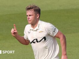 Sam Curran with his finger in the air after taking a wicket for Surrey