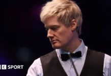 Neil Robertson looks on