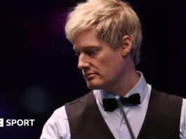 Neil Robertson looks on